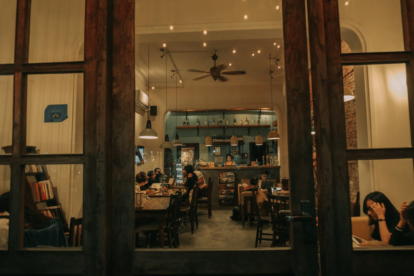 East Asian customers enjoy coffee in a cozy cafe.